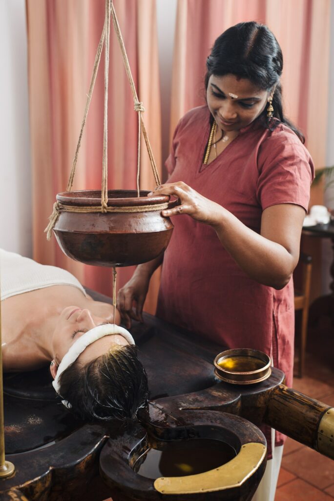 Caucasian woman having Ayurveda shirodhara treatment in India, Kerala state